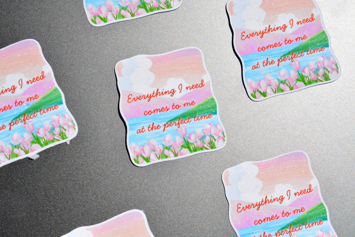 Everything I need comes to me at the perfect time list of stickers showcased on laptop