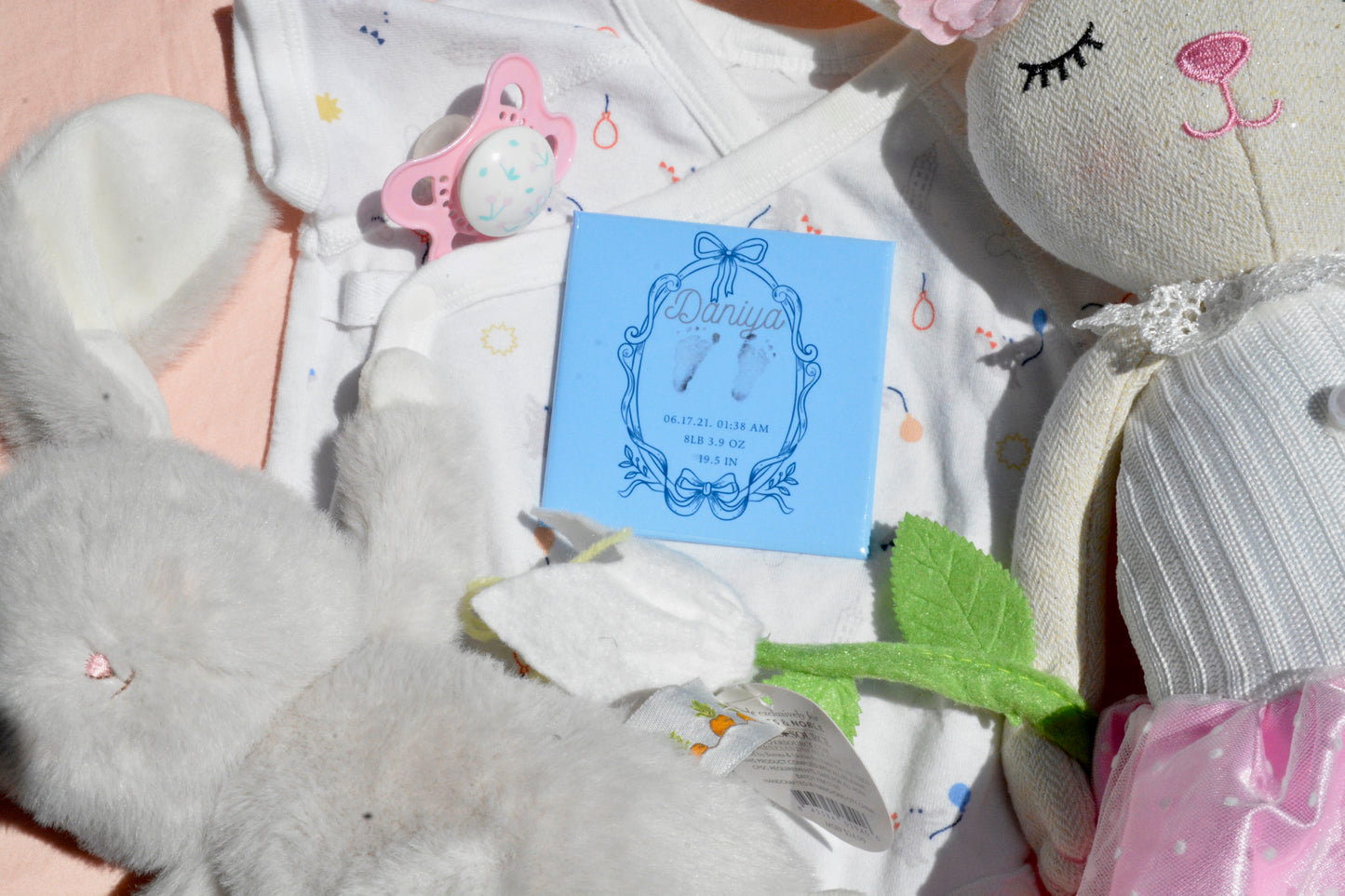 Personalized blue newborn footprint magnet with baby stats on toy background.
