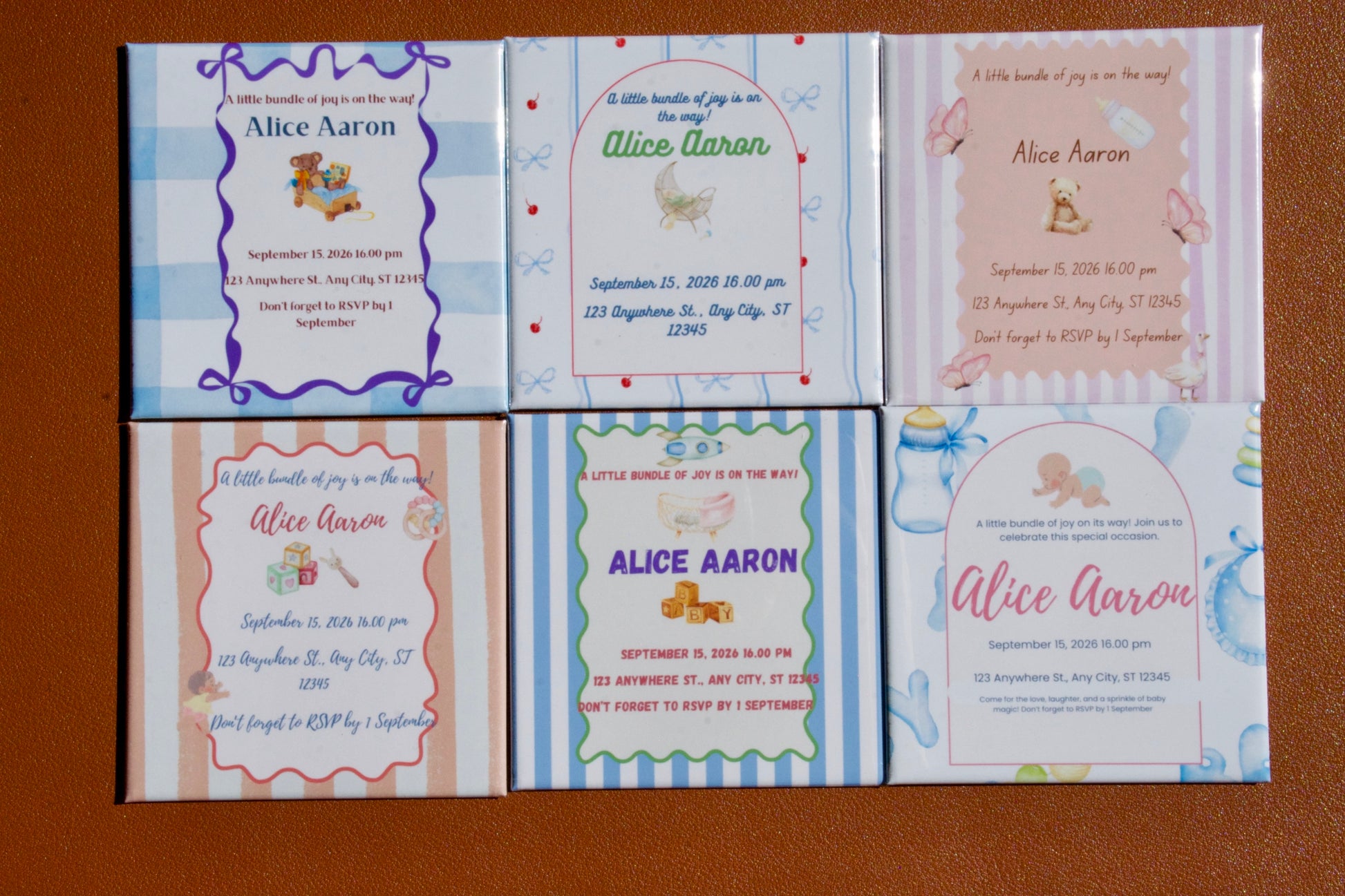 Set of baby shower magnet invitations with different designs on a brown background