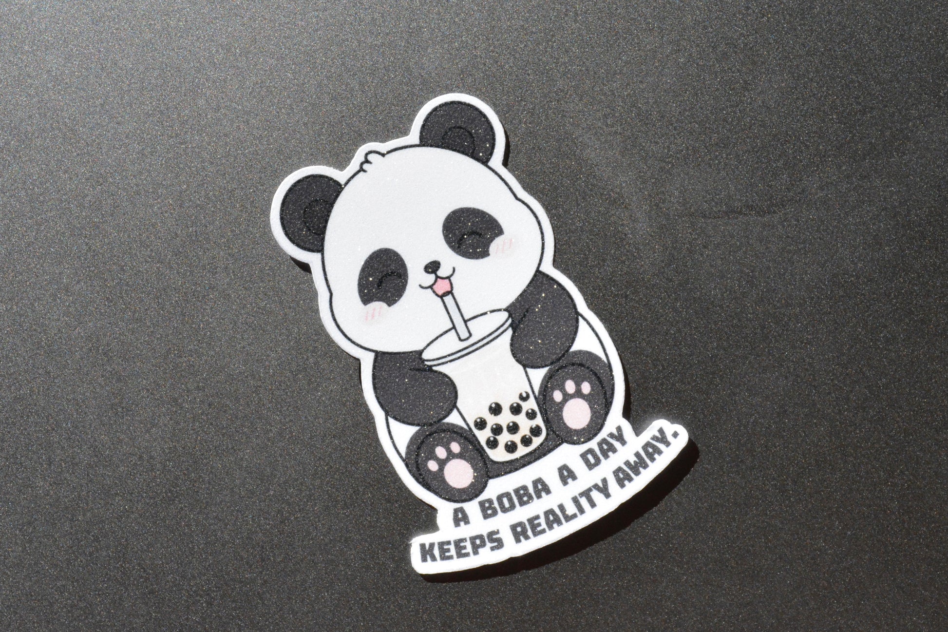 Happy panda on a sticker that says a boba a day keeps reality away