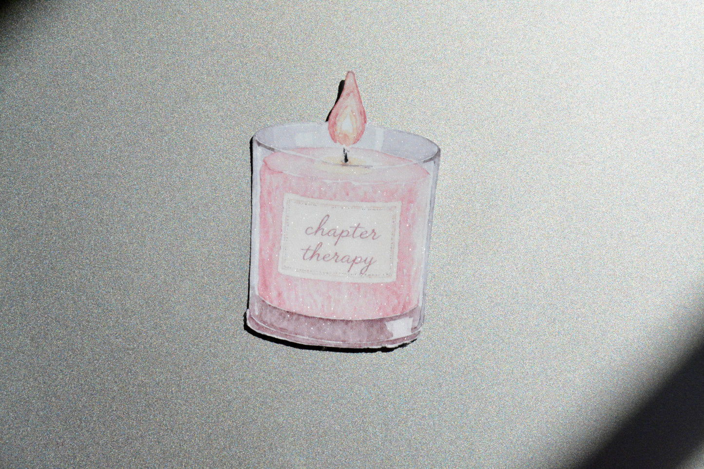 Chapter Therapy holographic watercolor candle sticker on a silver glittery surface