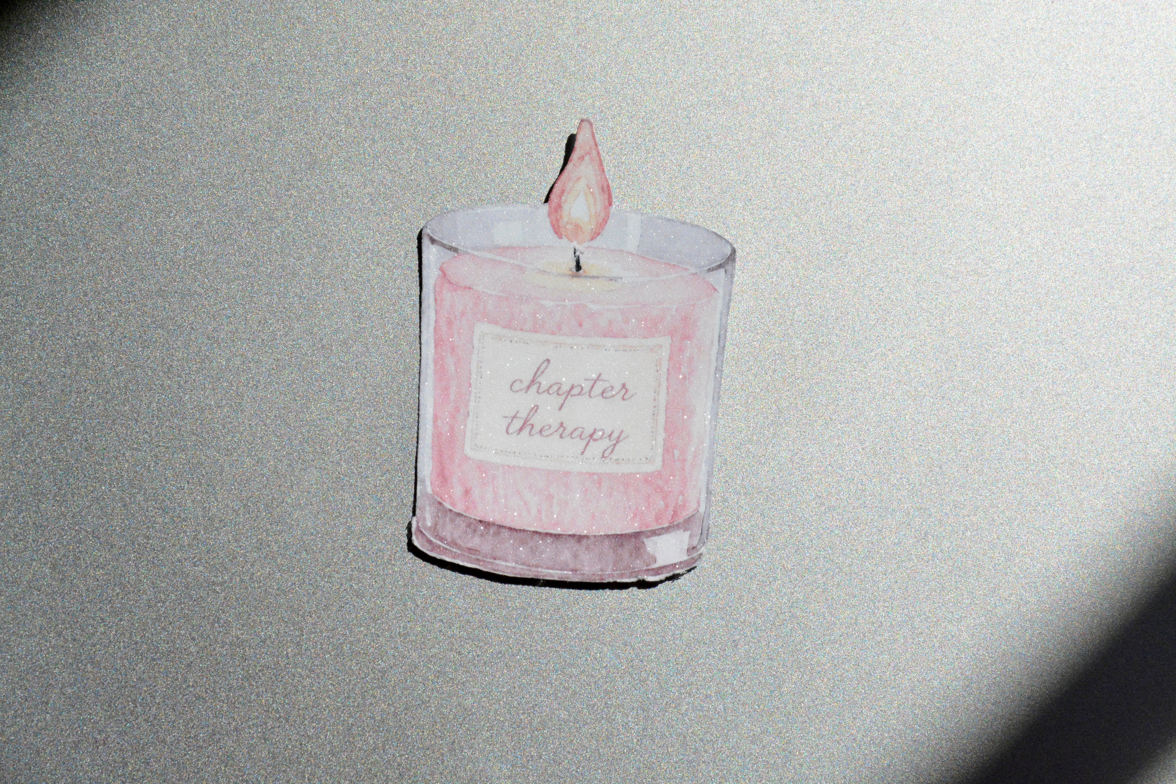 Chapter Therapy holographic watercolor candle sticker on a silver glittery surface