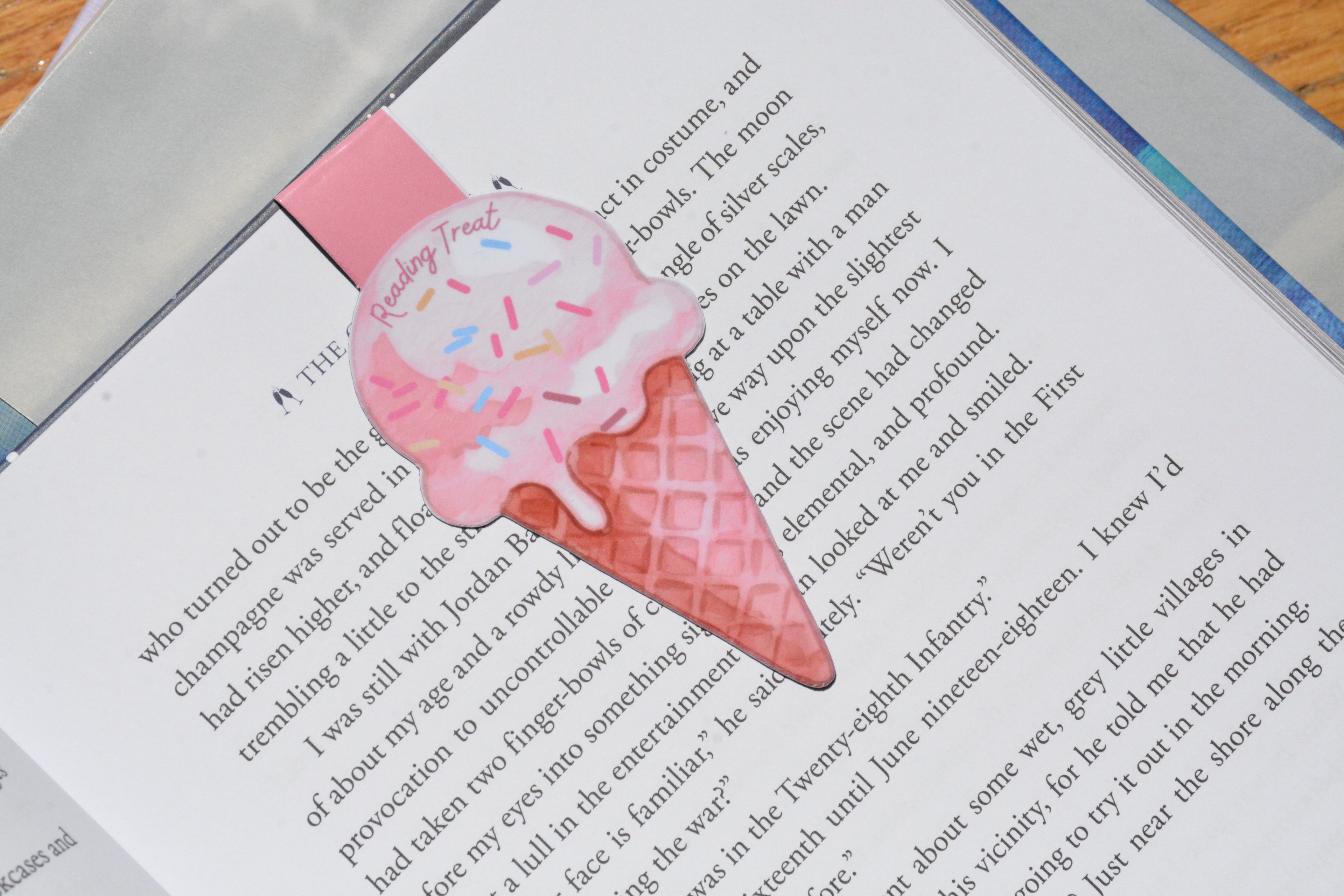 Cute ice cream magnetic bookmark clipped inside an open book, featuring a watercolor "Reading Treat" design for book lovers.