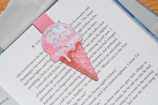 Cute ice cream magnetic bookmark clipped inside an open book, featuring a watercolor "Reading Treat" design for book lovers.