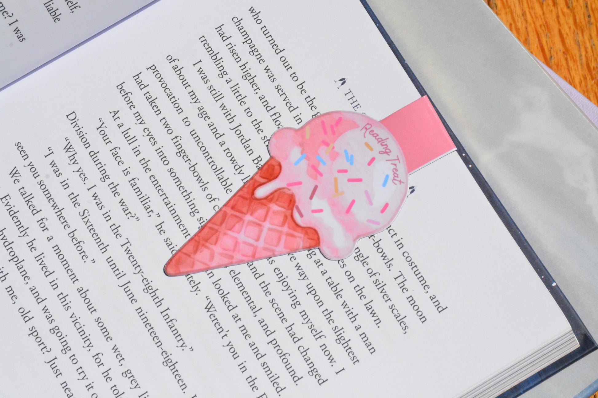Handmade pink ice cream magnetic bookmark marking a page in a novel, perfect for readers, students, teachers, and book lovers.