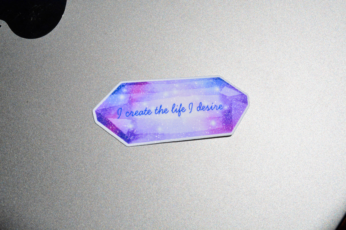 I create the life I desire sticker is on top of the grey surface