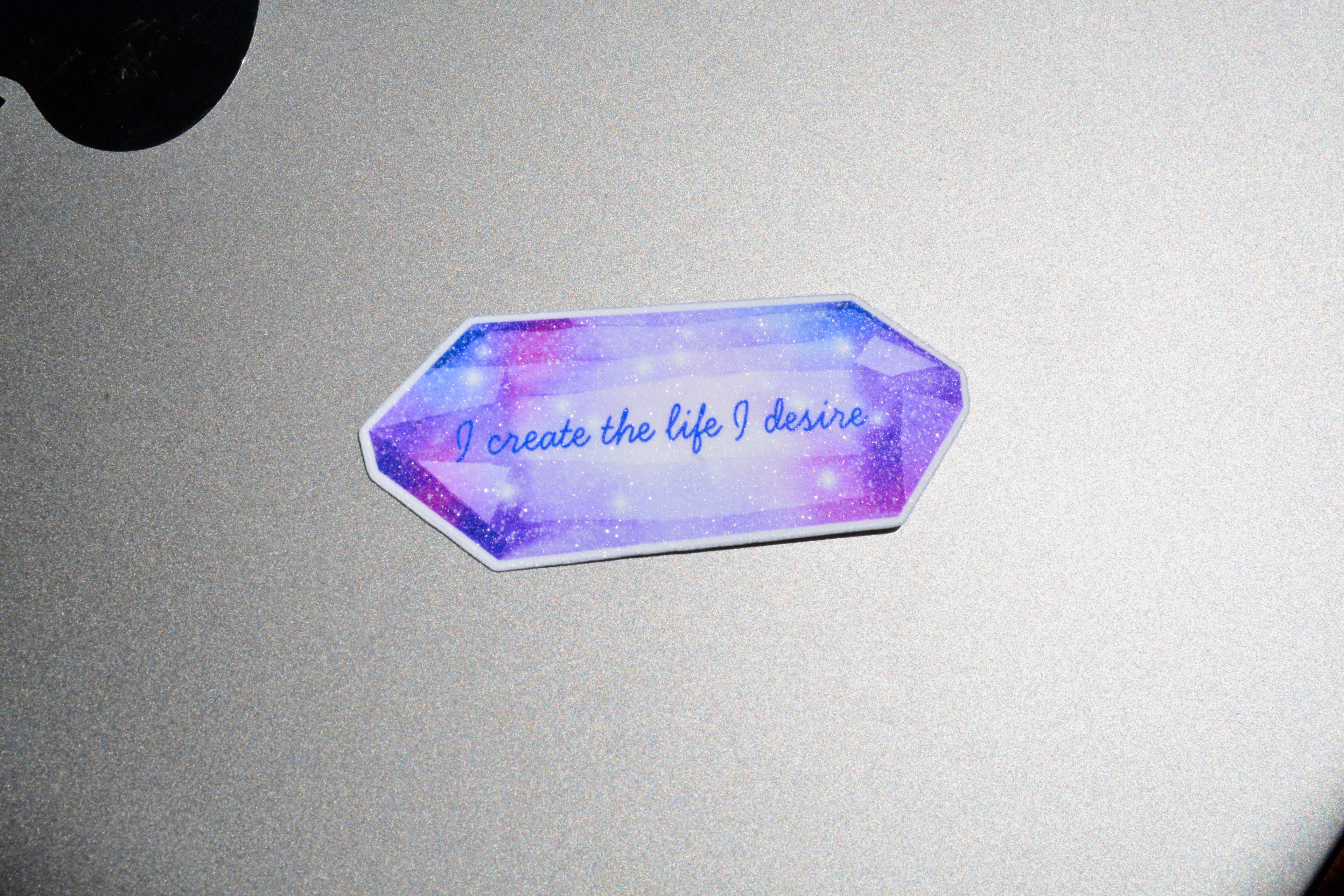 I create the life I desire sticker is on top of the grey surface
