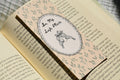 Handcrafted floral linen bookmark with a soft blush background and elegant illustration for book lovers.
