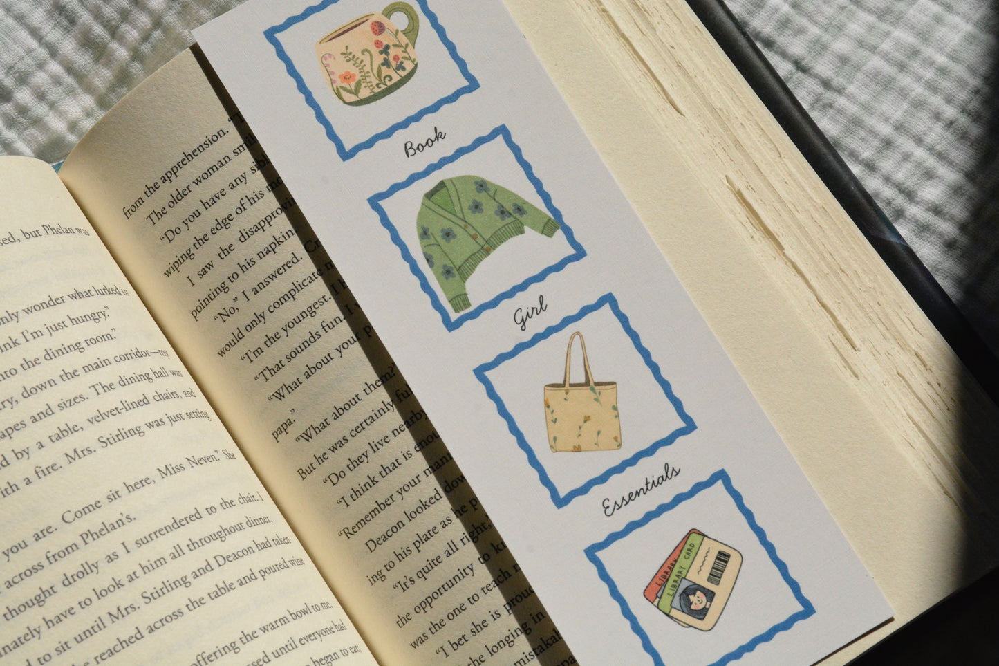 Oversized double-sided linen bookmark featuring cozy book lover essentials tucked inside an open book.