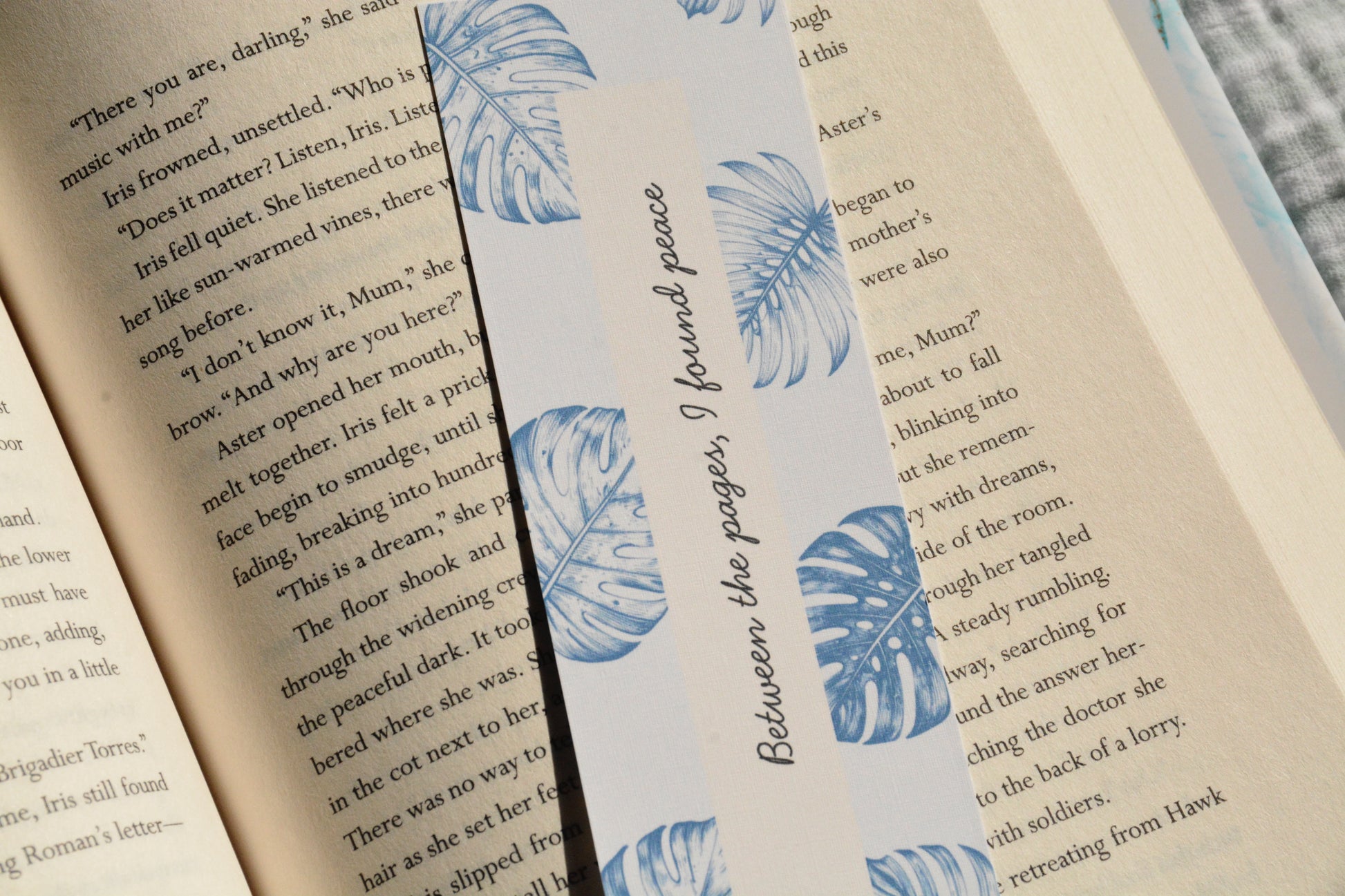 Minimalist linen bookmark with soft blue tropical leaves and a peaceful bookish quote for readers.