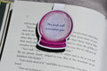 This Book Will Traumatize You magnetic bookmark clipped inside an open fantasy novel.