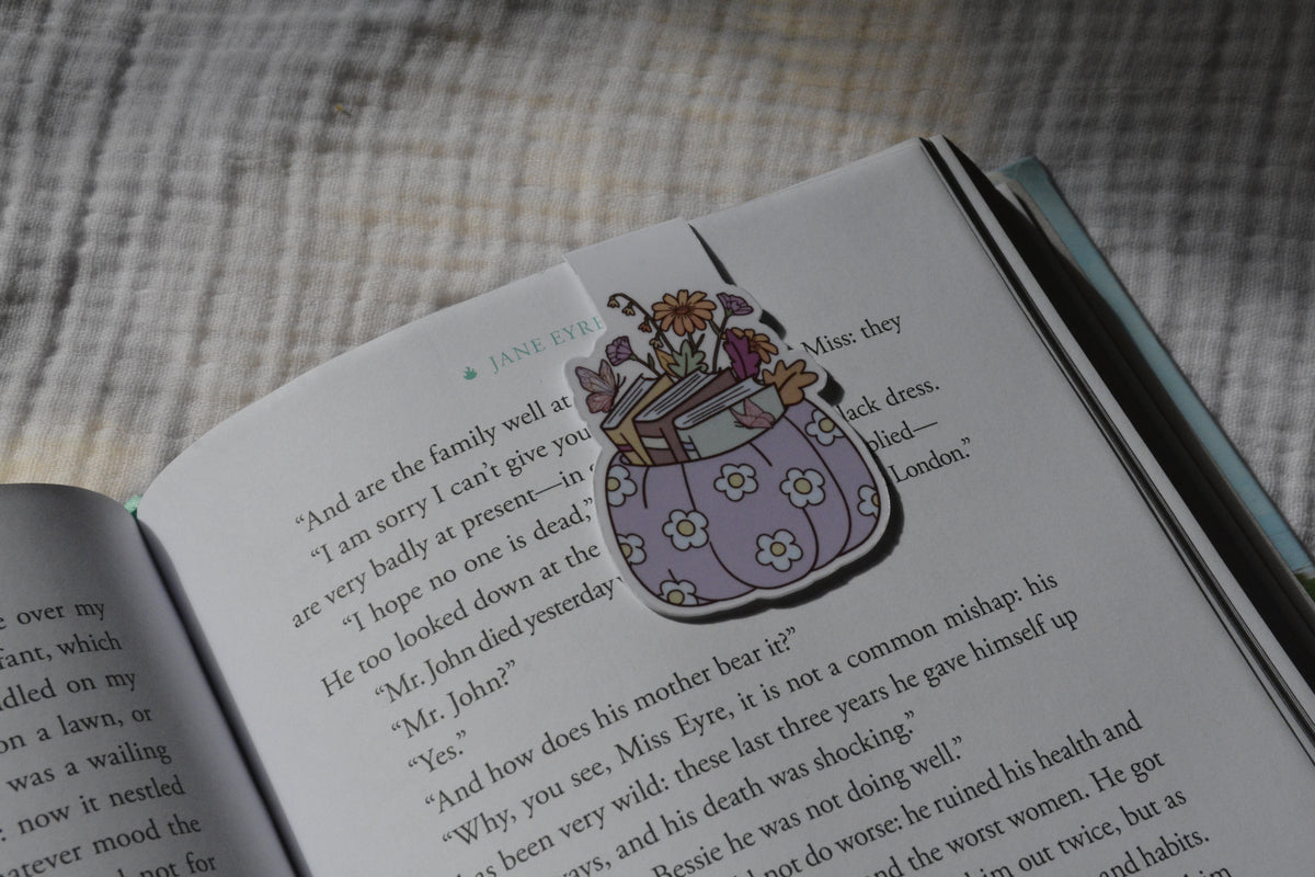 Handmade magnetic bookmark featuring a pumpkin stacked with books design on a pink Keepsake House backing card
