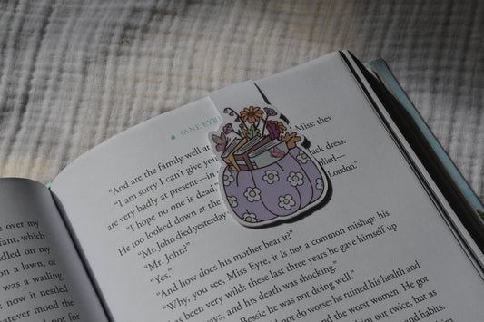 Handmade magnetic bookmark featuring a pumpkin stacked with books design on a pink Keepsake House backing card