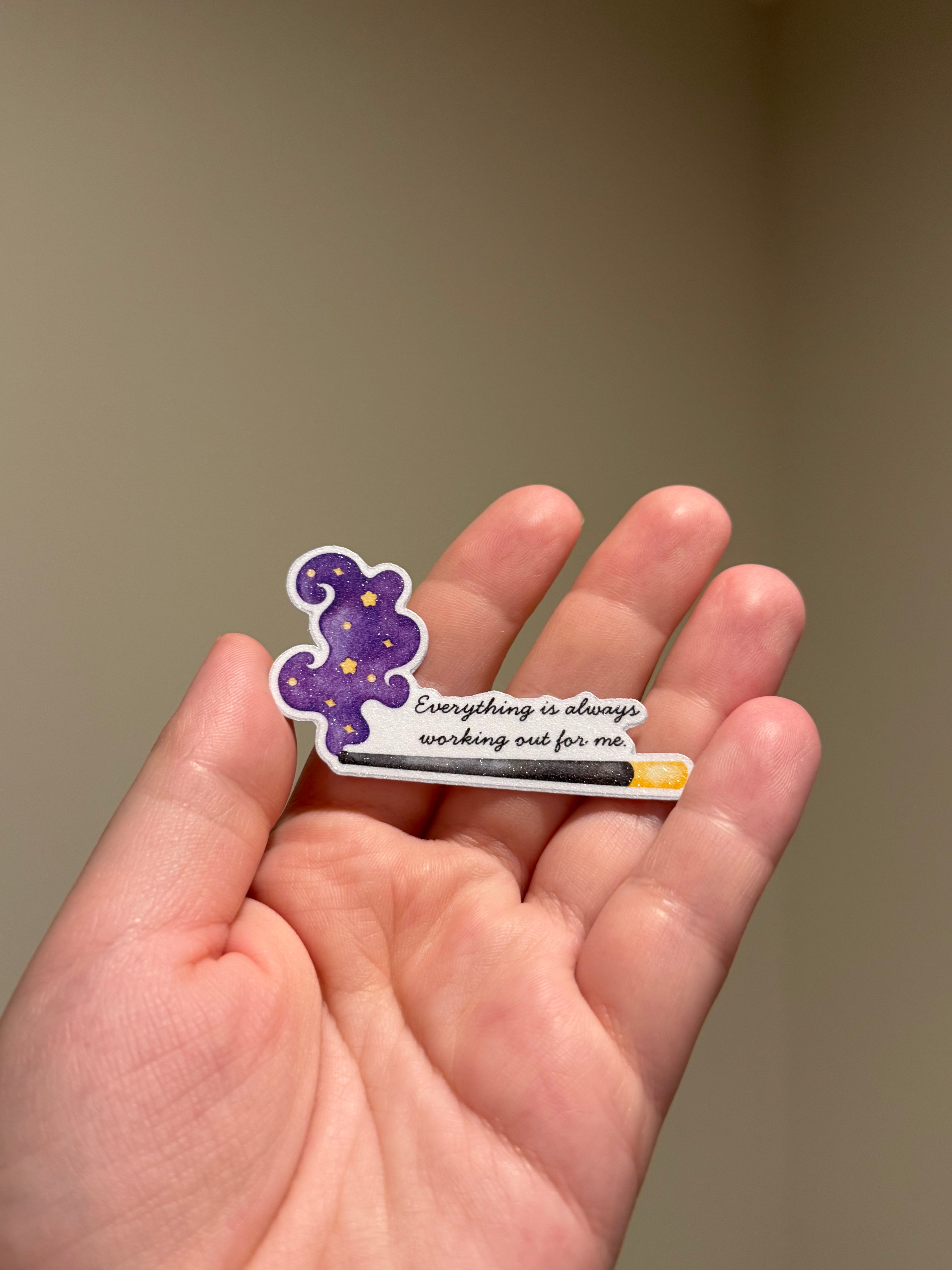 Purple glitter affirmation sticker with the quote "Everything is always working out for me" displayed in hand for Kindles, journals, planners, laptops, and water bottles.