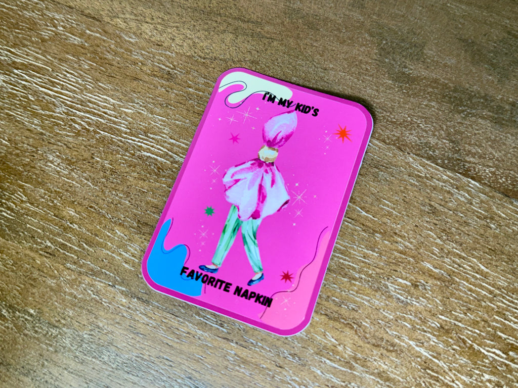 Funny "I'm My Kid's Favorite Napkin" mom sticker with a watercolor illustration on a bright pink background and a transparent laminate finish.