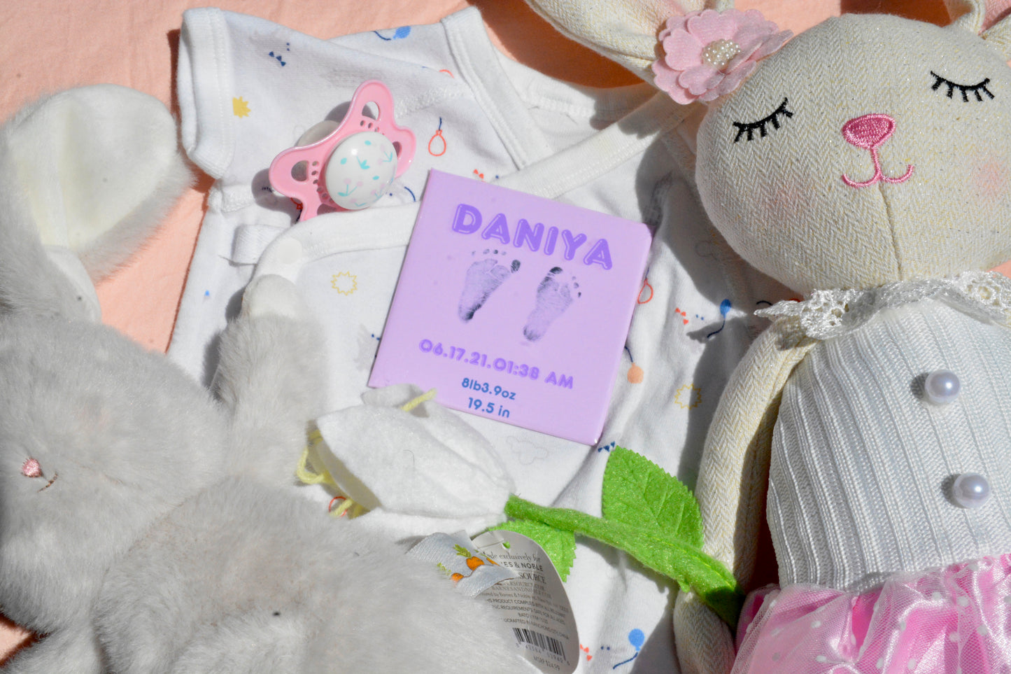 Personalized purple newborn footprint magnet centered on blanket background with birth stats.