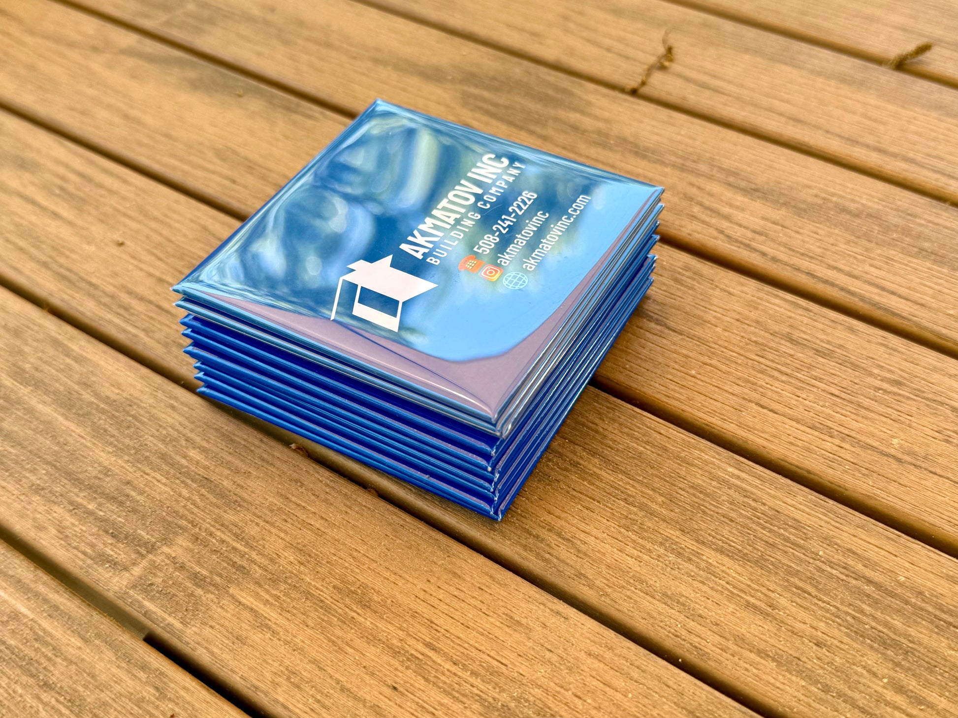 Stacks of custom blue logo magnet displayed on oak table background