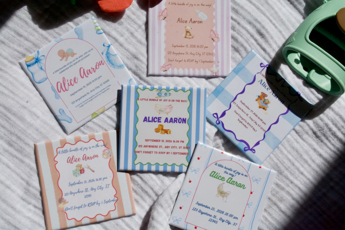 Collection of baby shower magnets invitations for Alice Aaron on a textured surface.