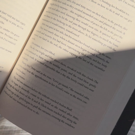 Video showcasing the oversized "A Little Escape" linen bookmark with its vintage toile pattern and premium linen texture while reading.