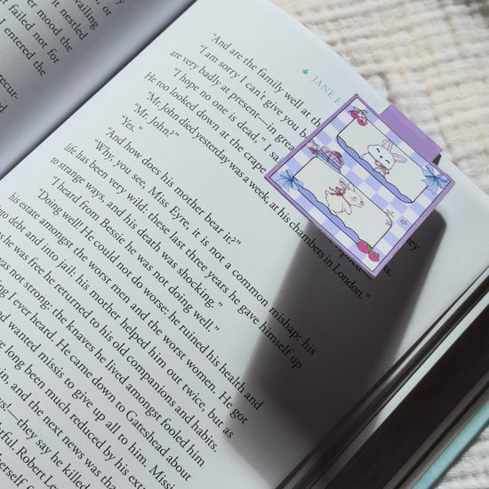 Magnetic bookmark demo: adorable kawaii bunny design slides onto book page and stays put with strong magnet, shown on pink Keepsake House backing card