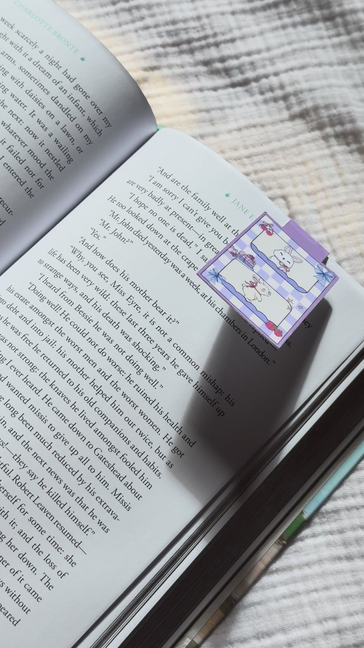 Magnetic bookmark demo: adorable kawaii bunny design slides onto book page and stays put with strong magnet, shown on pink Keepsake House backing card
