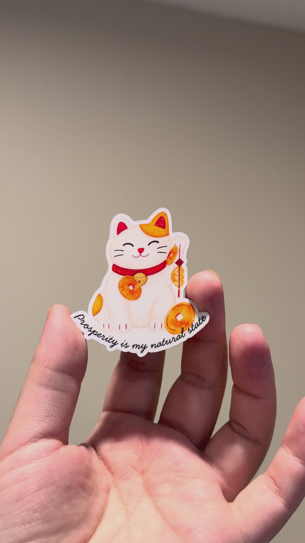 Video shows lucky cat glitter affirmation sticker with the quote "Prosperity is my natural state."