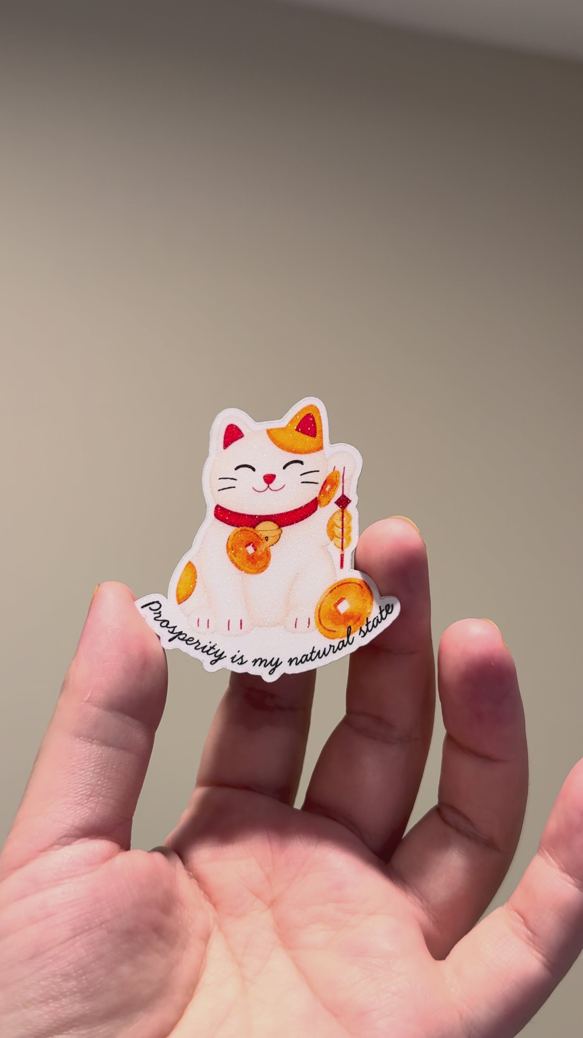 Video shows lucky cat glitter affirmation sticker with the quote "Prosperity is my natural state."