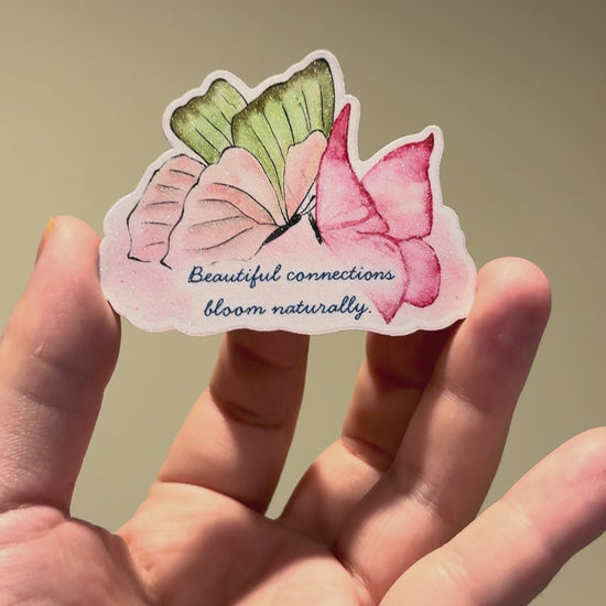 Close-up video of a watercolor butterfly affirmation sticker with glitter laminate, showcasing its sparkling finish and handmade details from different angles.