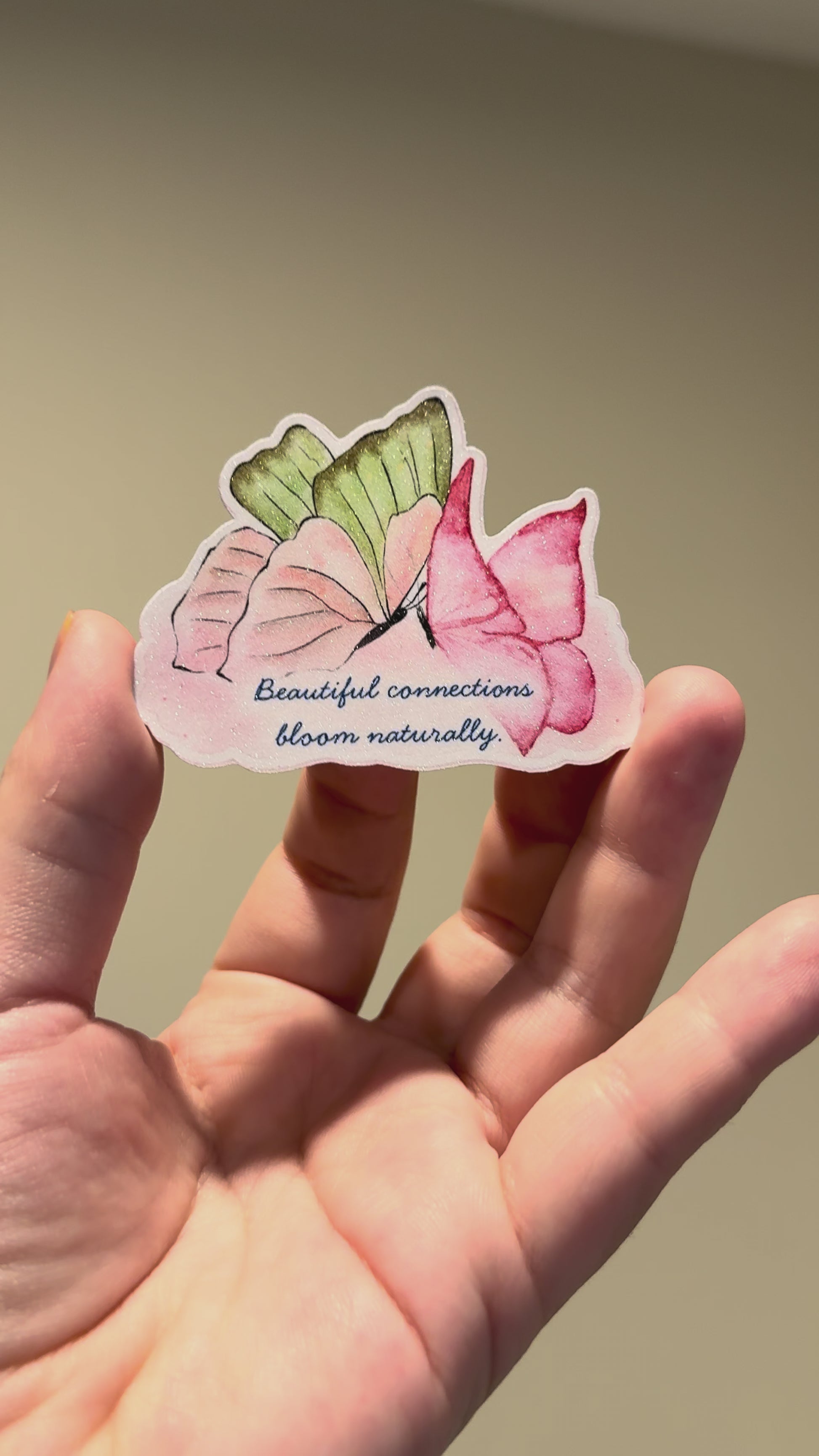 Close-up video of a watercolor butterfly affirmation sticker with glitter laminate, showcasing its sparkling finish and handmade details from different angles.