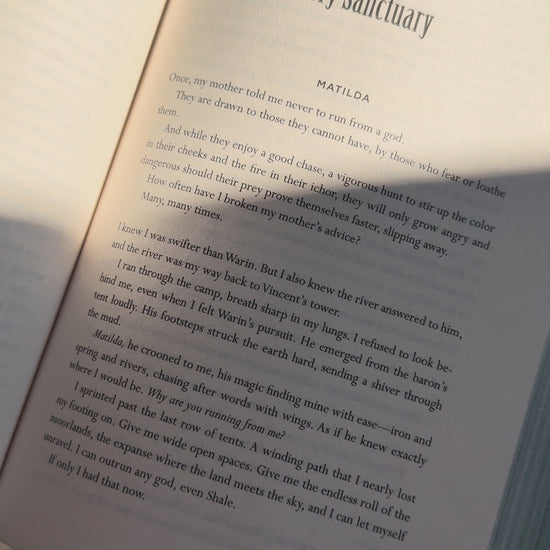 Video showing a handcrafted avocado linen bookmark with a watercolor pattern being used while reading a book.
