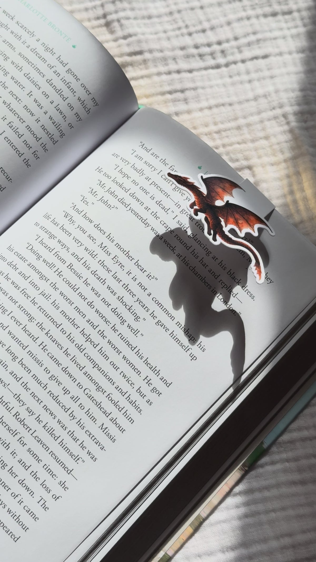 Dragon magnetic bookmark demo: cute fantasy dragon design clips securely onto book pages with strong magnetic closure, shown on pink Keepsake House backing card